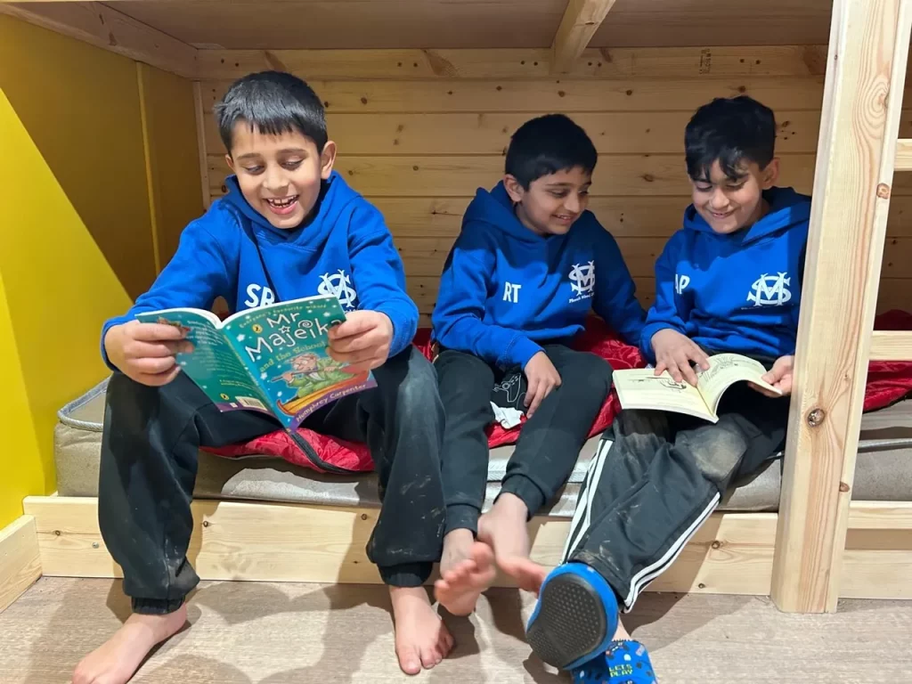 three school boys reading books 
